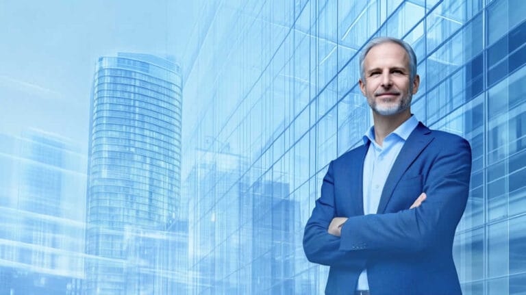 Confident businessman standing in front of modern skyscraper.
