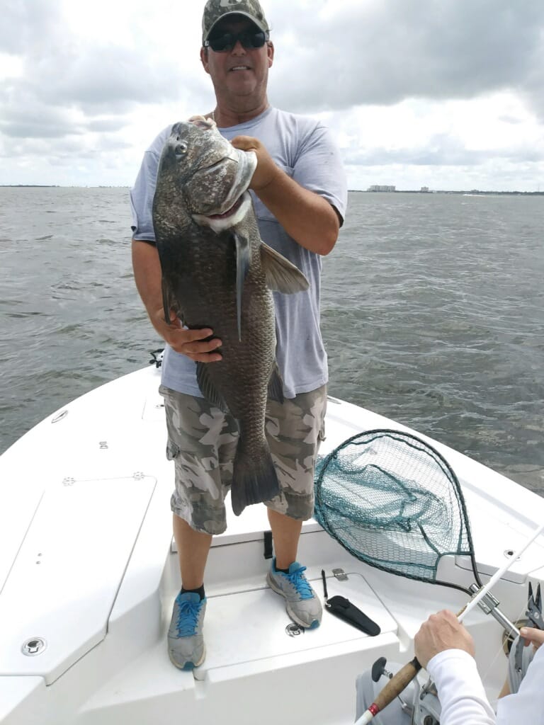 Person holding large fish on a boat