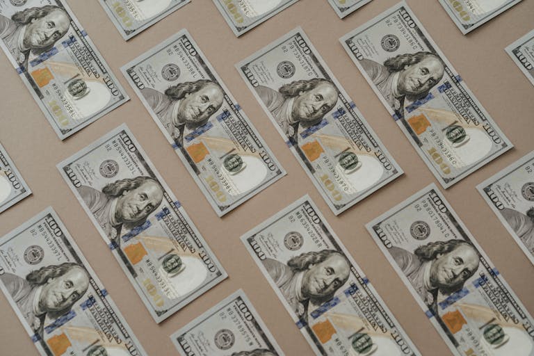 Close-up of multiple US dollar bills arranged in a grid pattern.