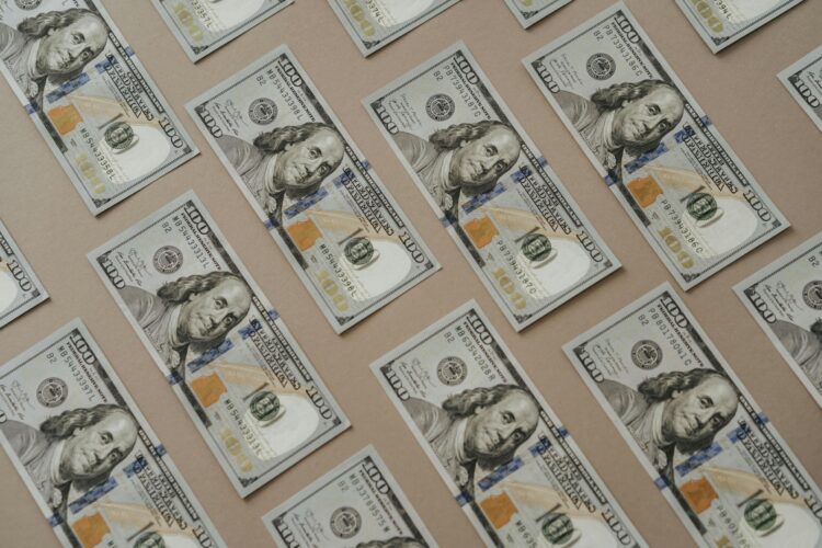 Close-up of multiple US dollar bills arranged in a grid pattern.
