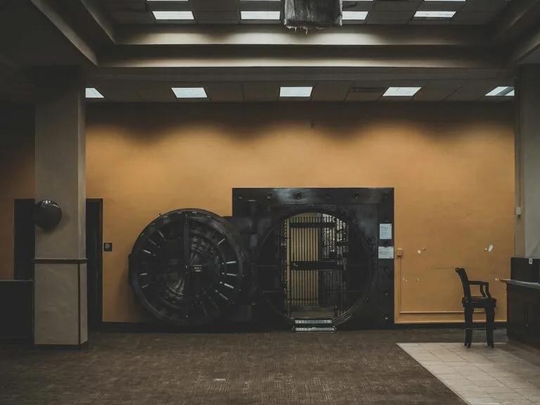 A spacious bank interior showcasing a large, open vault door under a modern ceiling.