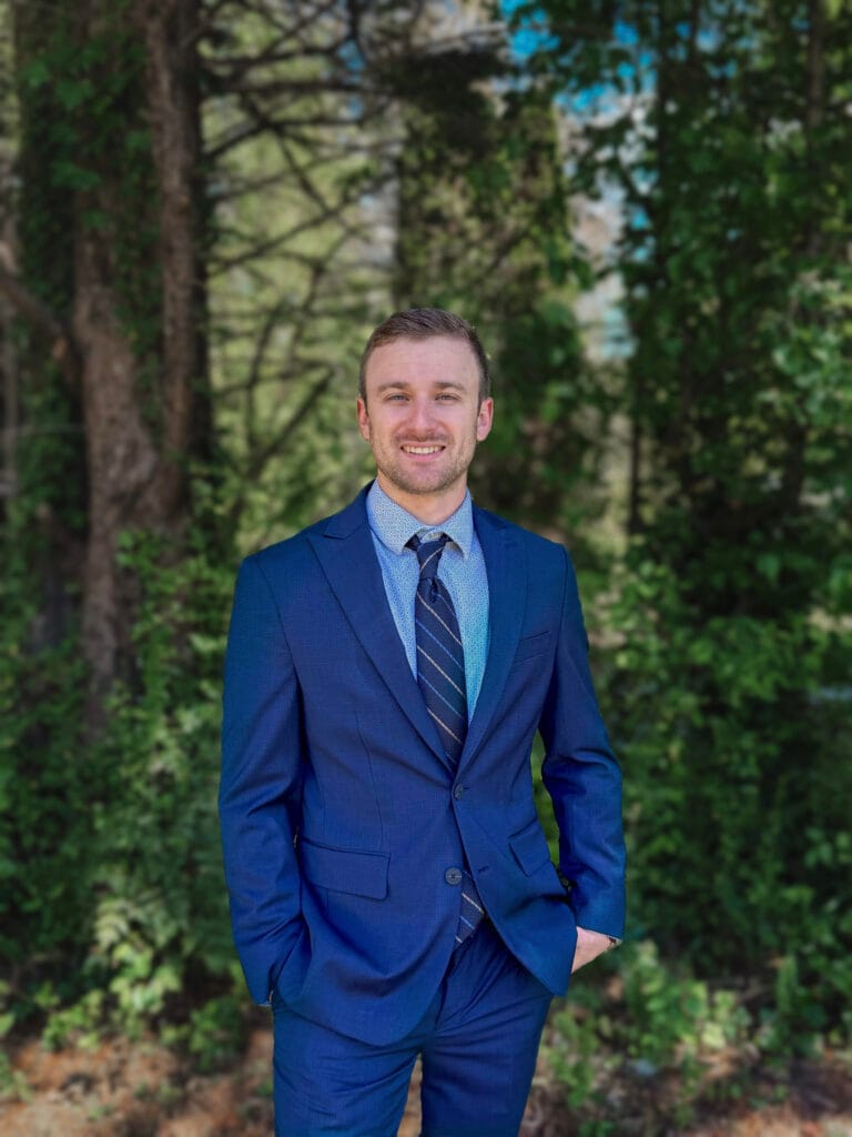 Young professional man in blue suit smiling outdoors