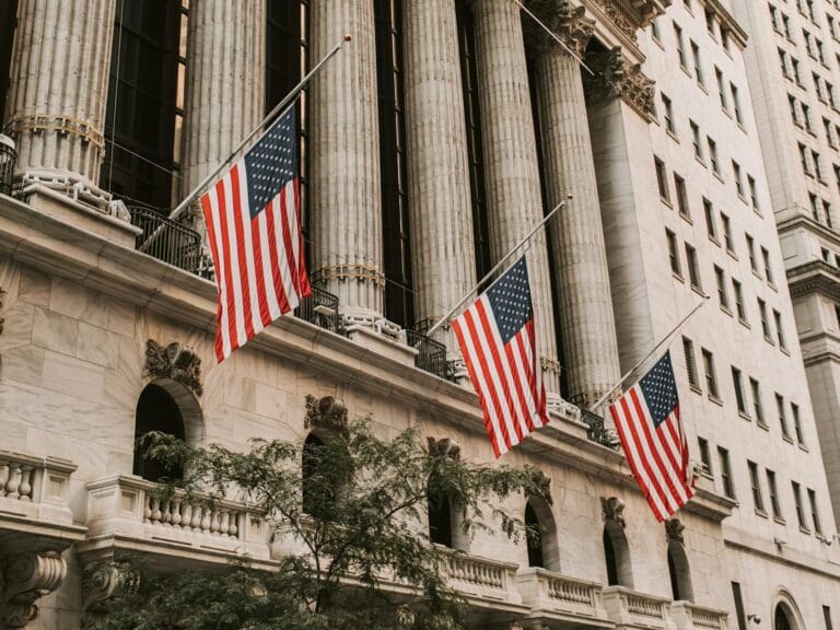 Iconic New York Stock Exchange with American flags on Wall Street, USA.