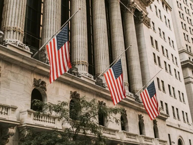 Iconic New York Stock Exchange with American flags on Wall Street, USA.